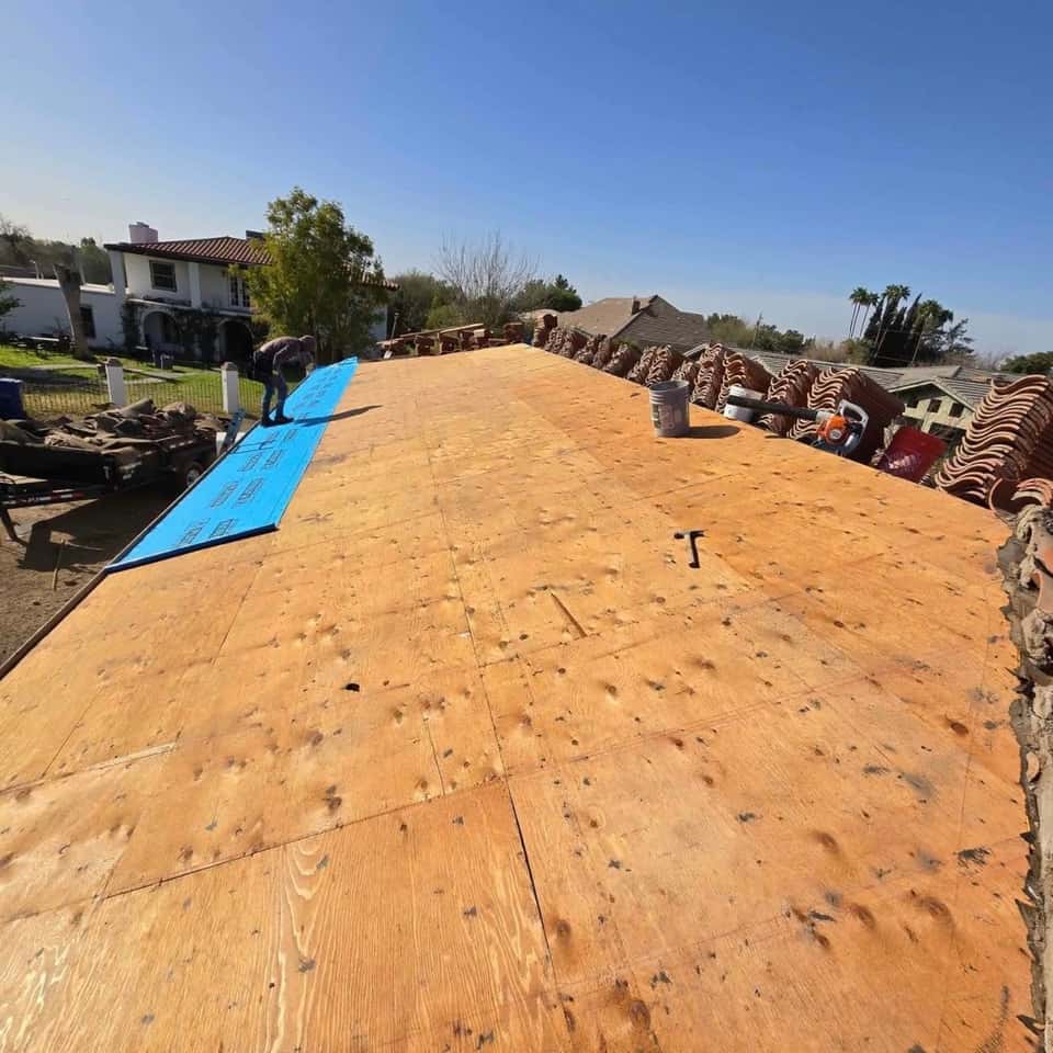 New plywood roof decking with a blue tarp, ready for underlayment — Cristian House Remodeling LLC