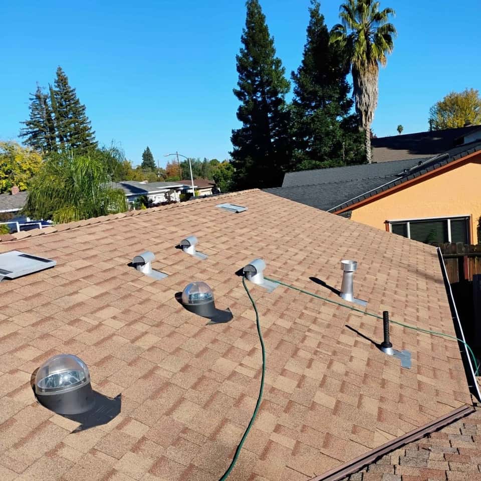Tan shingle roof with a new vent boot, seen from the ridge — Cristian House Remodeling LLC