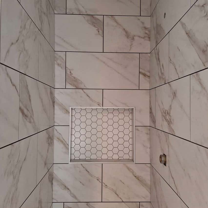 Marble-look tile shower wall with a mosaic niche — Cristian House Remodeling LLC