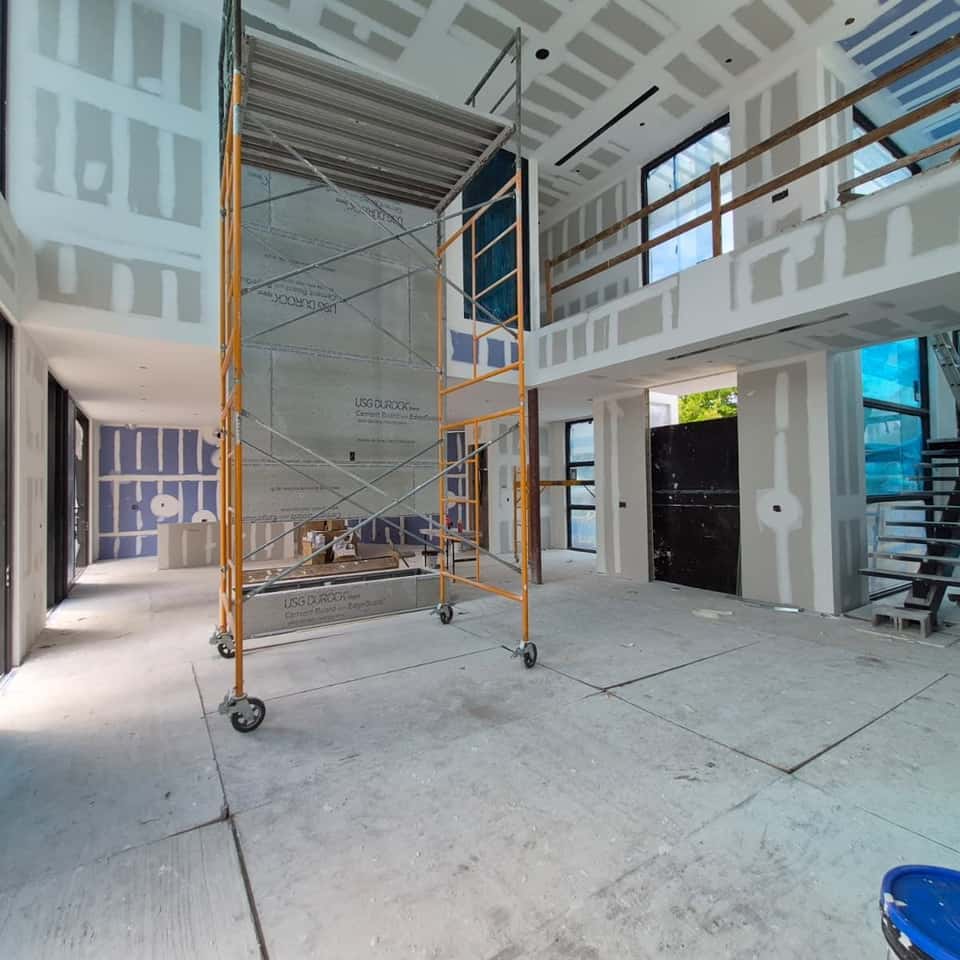 Double-height drywall and cement board going up with scaffolding — Cristian House Remodeling LLC
