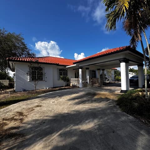 Finished white stucco home with a new barrel-tile roof in full sun — Cristian House Remodeling LLC